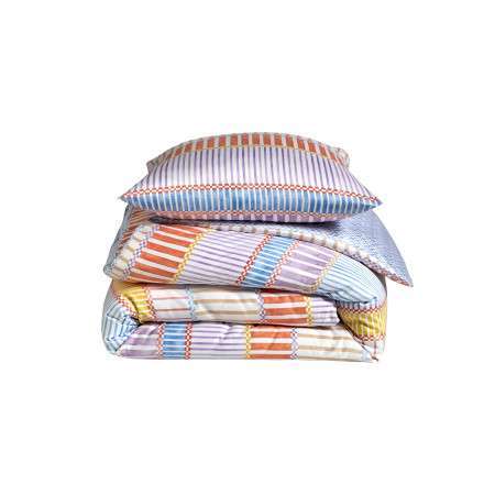 INTERIEUR-DECORATION|Parure PORTOFINO PASTELParure PORTOFINO PASTELBLANC DES VOSGESParure de litParure PORTOFINO PASTEL La housse de couette PORTOFINO en satin de coton transforme la chambre avec élégance grâce à son motif de rayures aquarellées modernes. Déclinée en deux harmonies, Ultraviolet pour un rendu profond et contemporain, et Pastel pour une ambiance douce et lumineuse, elle habille le lit d’une atmosphère estivale et raffinée. Conçue pour allier confort et praticité, la housse de couette PORTOFINO est dotée d’un rabat cheminée, garantissant un maintien parfait de la couette et un tombé net au pied du lit, pour un rendu soigné et élégant au quotidien. Confectionnée en satin de coton ultradoux au tissage extrêmement fin et serré, 120 fils/cm², la housse de couette PORTOFINO offre un toucher soyeux, une excellente tenue dans le temps et révèle toute la subtilité et la profondeur des couleurs. Fabriquée à Gérardmer, au cœur des Vosges, la housse de couette PORTOFINO est proposée dans les dimensions standards et peut également être réalisée en sur-mesure afin de s’adapter parfaitement à votre literie. Matière : Satin imprimé 100% coton peigné longues fibres 120 fils/cm² Finition : Rabat cheminée Drap-housse : Satin imprimé mini motifs géométriques coordonnés 